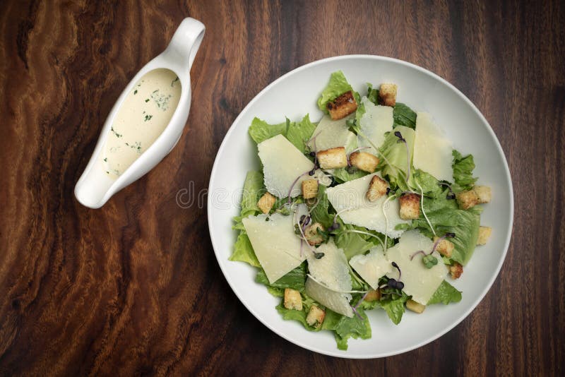 Caesar Salad with Parmesan Cheese and Croutons on Table Stock Photo