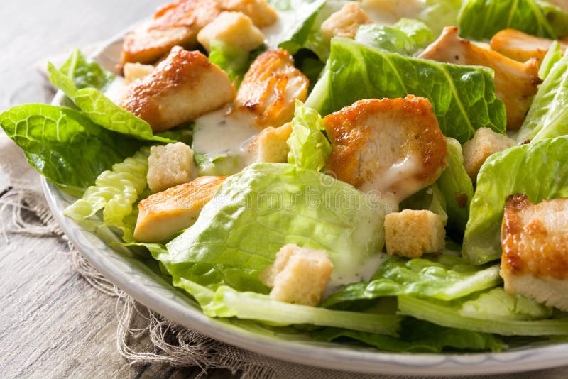 Caesar-Salat Mit Kopfsalat, Huhn Und Croutons Auf Holztisch Stockbild ...