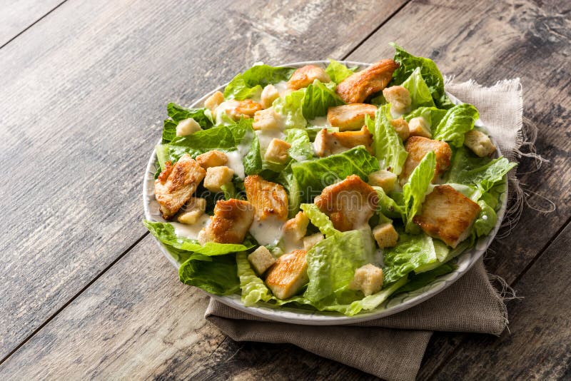 Caesar-Salat Mit Kopfsalat, Huhn Und Croutons Auf Holztisch Stockbild ...