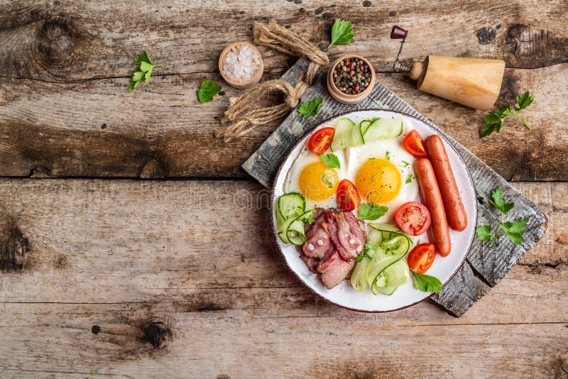 Café da manhã inglês com ovos fritos, bacon, queijo, tomate no