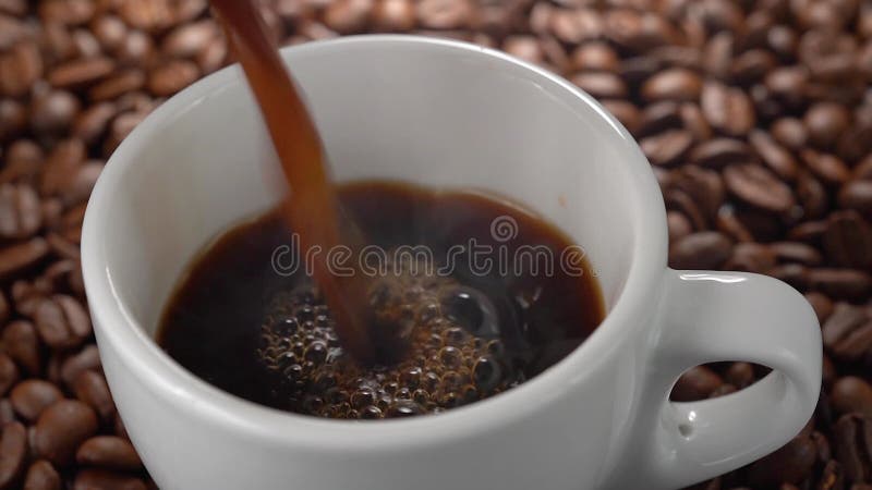 Le gobelet de café noir et des grains de café Photos