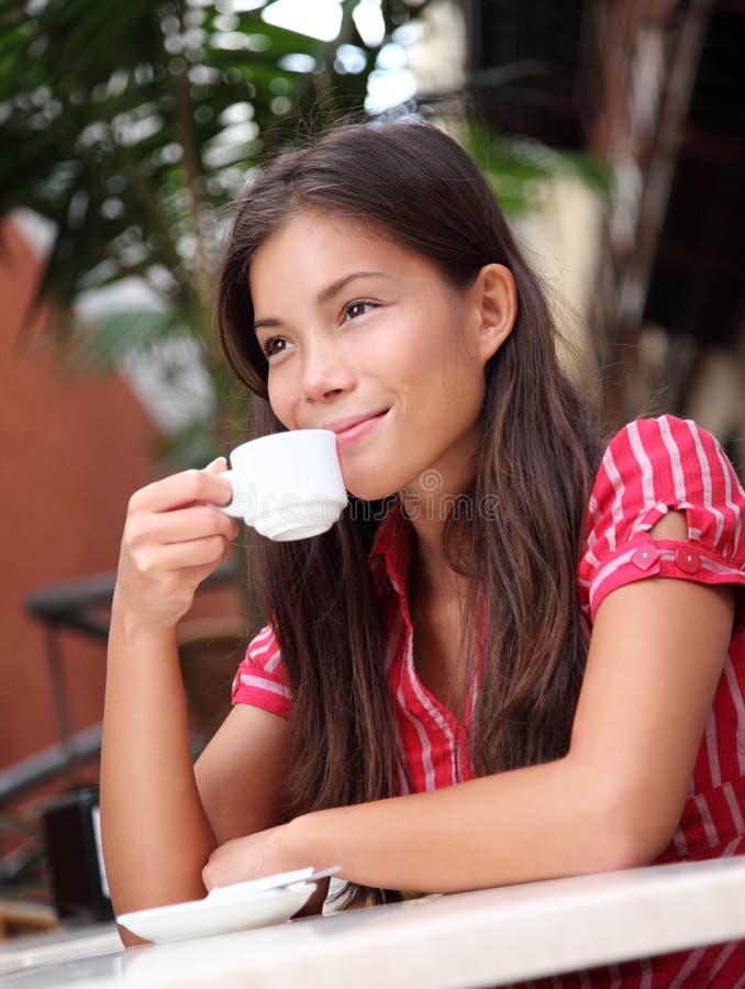 Cafe. Woman drinking coffee at a sidewalk  outdoors. Attractive mixed race chinese / caucasian model stock photography
