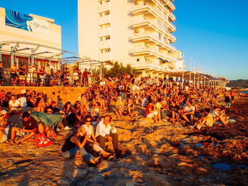 IBIZA,SPAIN - JUNE 22: people relax at Cafe del Mar Beach at the sunset,on 22th of june 2010 in Ibiza, Spain. Cafe del mar has become famous worldwide for its sunset and the music collection that take its name. IBIZA,SPAIN - JUNE 22: people relax at Cafe del Mar Beach at the sunset,on 22th of june 2010 in Ibiza, Spain. Cafe del mar has become famous worldwide for its sunset and the music collection that take its name