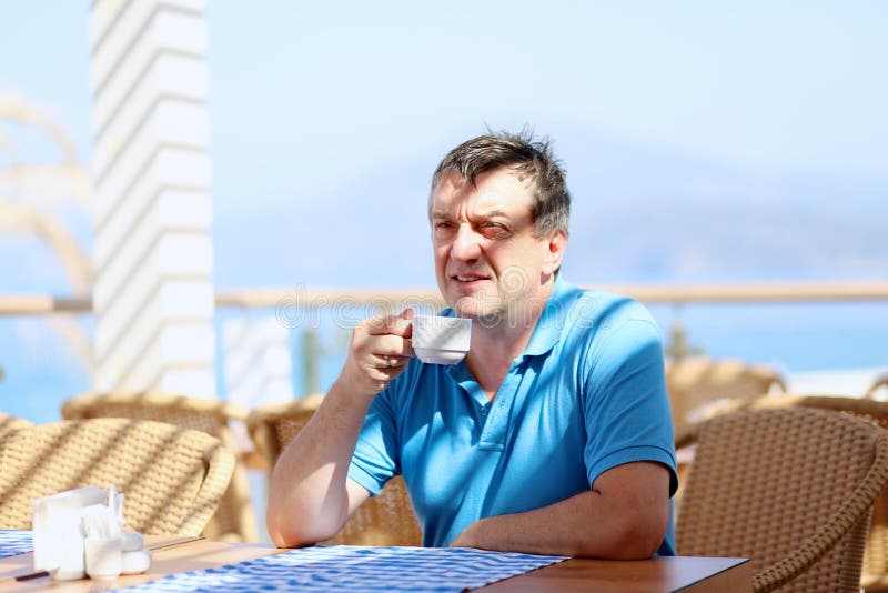Caffè bevente dell'uomo nel ristorante della località di soggiorno immagini stock libere da diritti Caffè bevente dell'uomo nel ristorante della località di soggiorno immagini stock libere da diritti