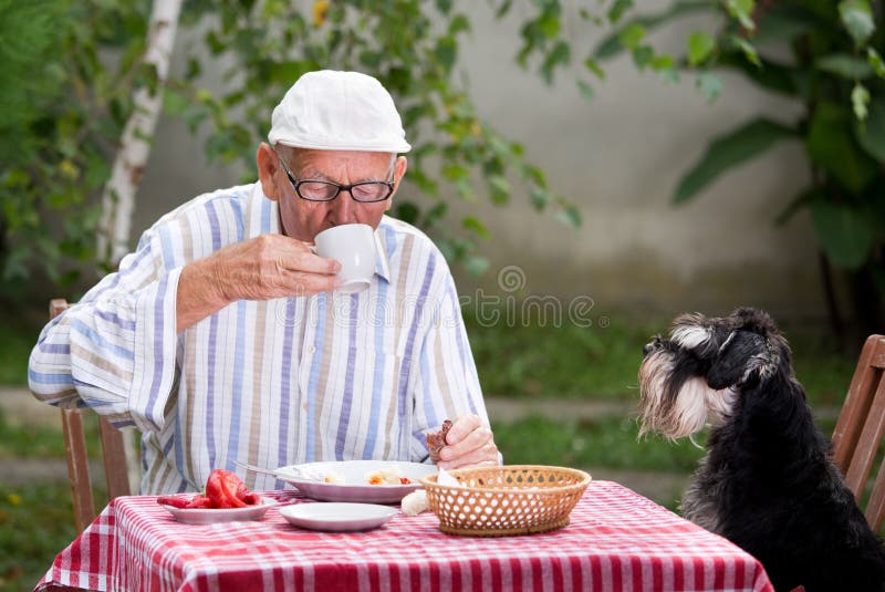 Caffè bevente dell'uomo senior in giardino fotografia stock libera da diritti Caffè bevente dell'uomo senior in giardino fotografia stock libera da diritti
