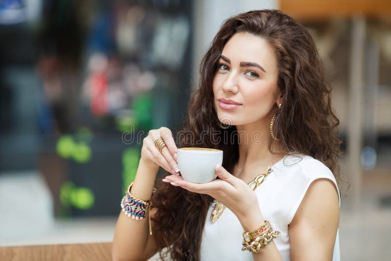 Caffè bevente della donna in un supermercato del caffè fotografia stock Caffè bevente della donna in un supermercato del caffè fotografia stock