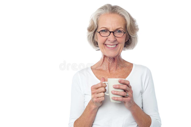 Caffè bevente sorridente della signora anziana occhialuta fotografia stock Caffè bevente sorridente della signora anziana occhialuta fotografia stock
