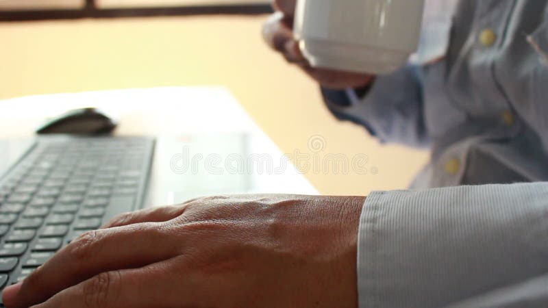 Caffè del giovane uomo d'affari e computer portatile beventi usando per il lavoro di affari nel fuoco vago