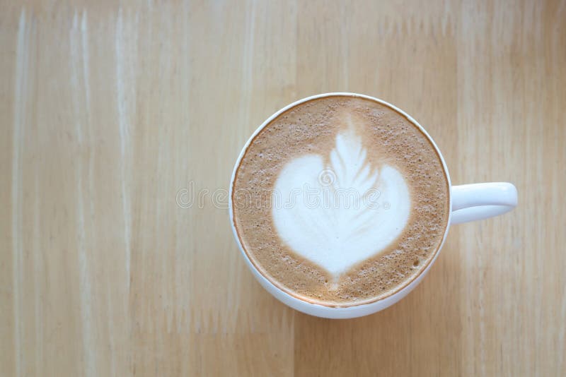 Caffè di arte del Latte sul fondo di legno della tavola fotografie stock Caffè di arte del Latte sul fondo di legno della tavola fotografie stock
