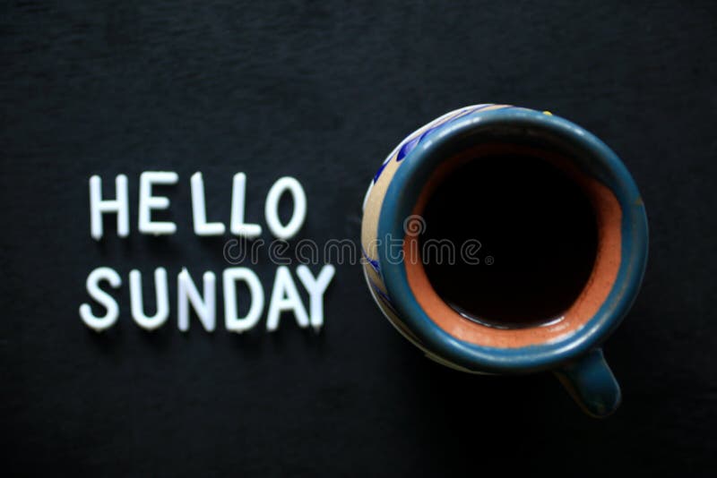 Caffè di domenica. una tazza di caffè mattutino sullo sfondo del tavolo nero con un cartello di testo sul tavolo scuro pronto per fotografia stock libera da diritti