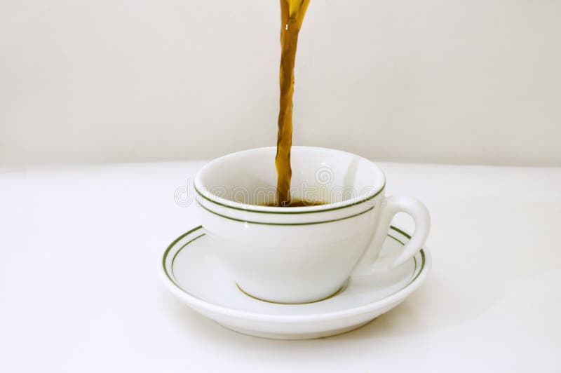 Black coffee being poured on a white cup over white background. Black coffee being poured on a white cup over white background