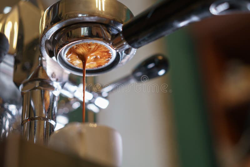 Caffè espresso che versa dal portafilter smisurato