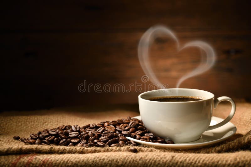 Caffè a forma di cuore fumato e chicchi di caffè su sacco di legno di vecchio sfondo di legno