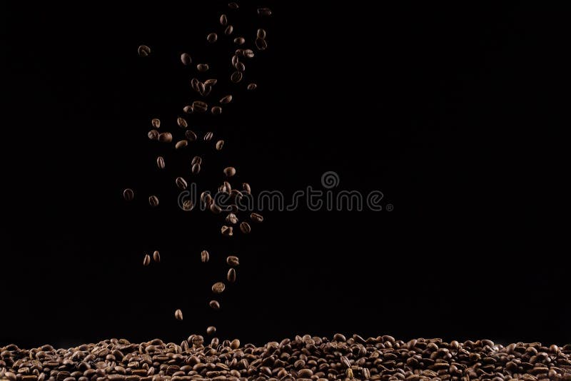 Caffè nell'aria che vola in volo come uno spray Su sfondo nero, concetto pubblicitario di caffetteria, copia spazio fotografia stock