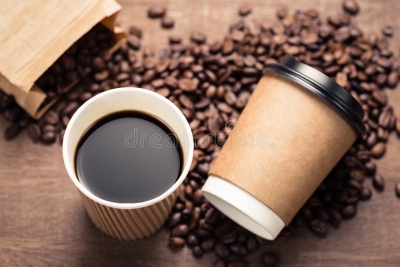 Caffè nero in tazza di carta ed in fagioli immagine stock