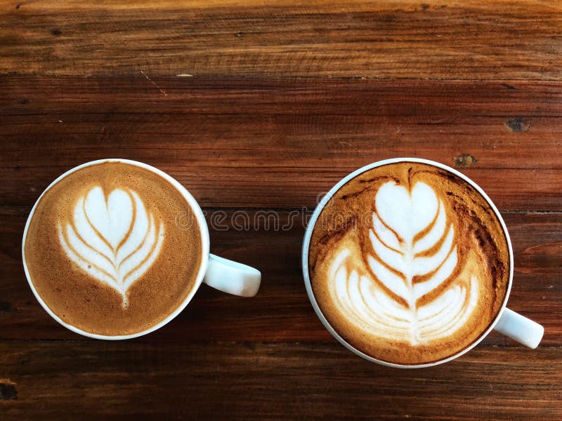 Caffè piccolo di arte del latte e caffè del cappuccino in tazza bianca