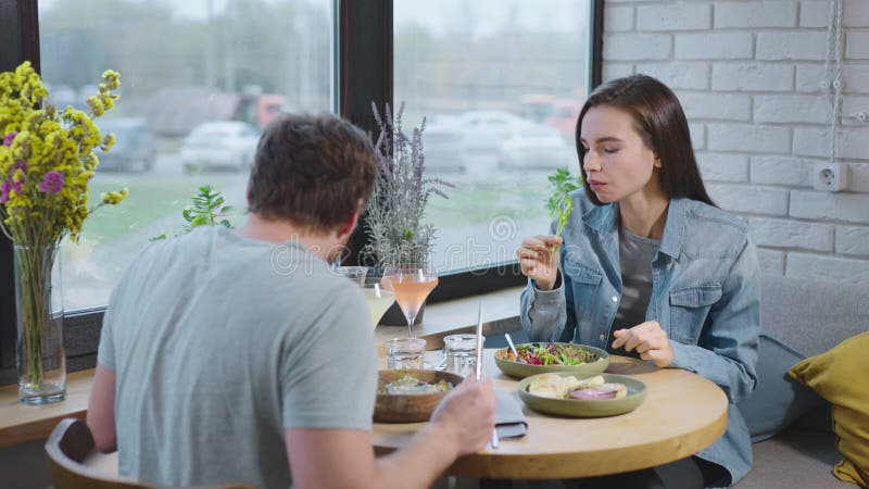 Caffé accogliente con cibo sano e saporito. un uomo e una donna comunicano durante una pausa pranzo. archivi video