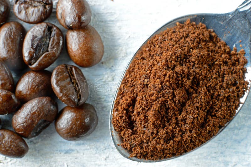 Cafè moulu en cuillère et grains de café sur un fond en bois images stock Cafè moulu en cuillère et grains de café sur un fond en bois images stock