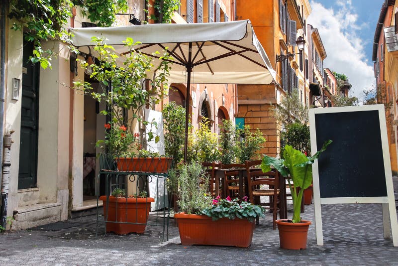 Café al aire libre en una calle estrecha en Roma, Italia