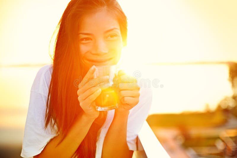 Café bebendo da mulher asiática no sol