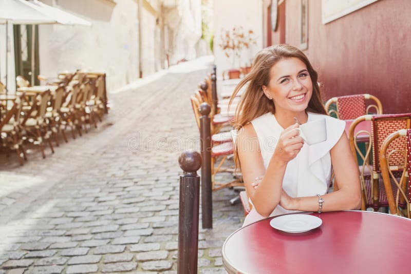 Café bebendo de sorriso da mulher no café da rua fotografia de stock royalty free Café bebendo de sorriso da mulher no café da rua fotografia de stock royalty free