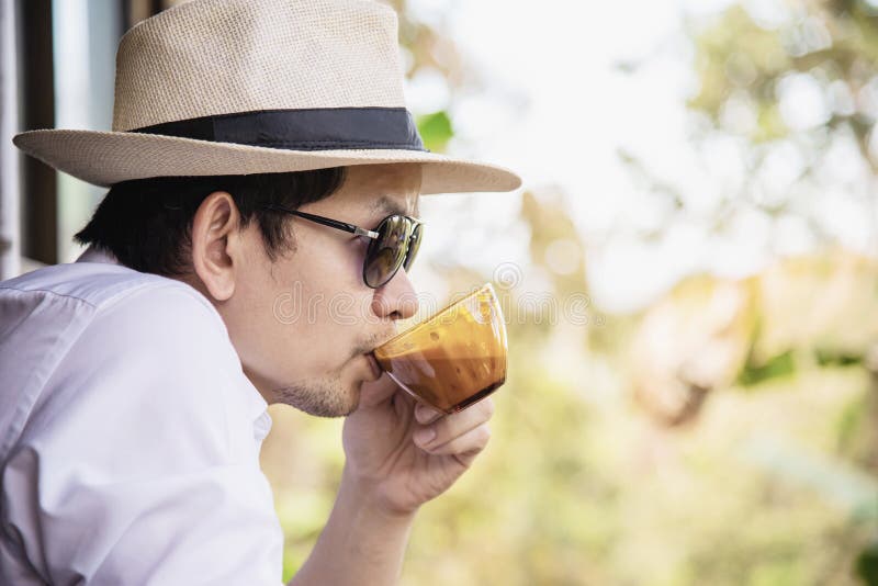 Café chaud de boissons asiatiques occasionnelles d'homme heureusement en nature photos libres de droits Café chaud de boissons asiatiques occasionnelles d'homme heureusement en nature photos libres de droits