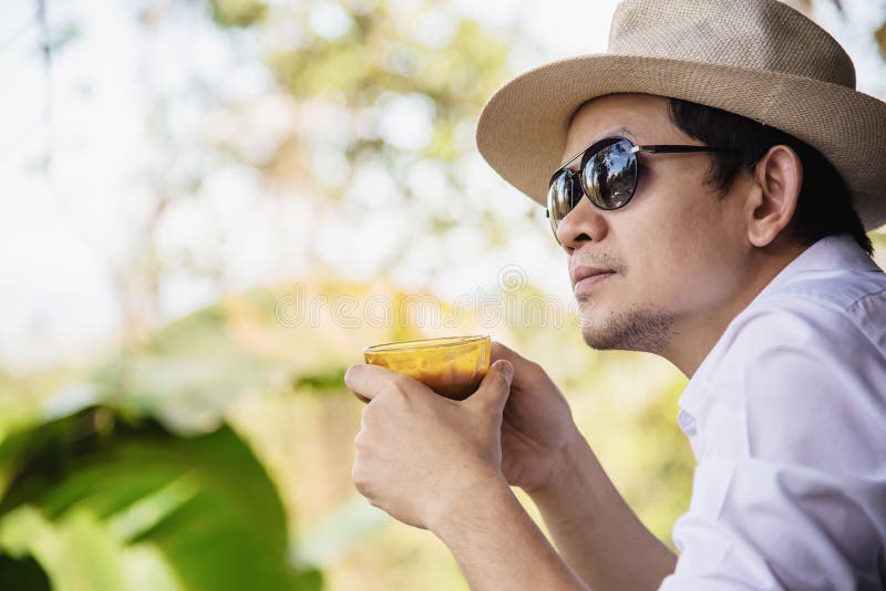 Café chaud de boissons asiatiques occasionnelles d'homme heureusement en nature photos stock Café chaud de boissons asiatiques occasionnelles d'homme heureusement en nature photos stock