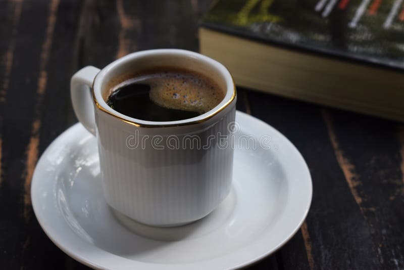 Café chaud de matin sur la table près du livre photo stock Café chaud de matin sur la table près du livre photo stock