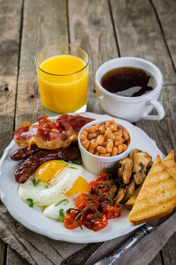 Café da manhã inglês completo - ovos, bacon, feijões, brinde, café e suco imagem de stock Café da manhã inglês completo - ovos, bacon, feijões, brinde, café e suco imagem de stock