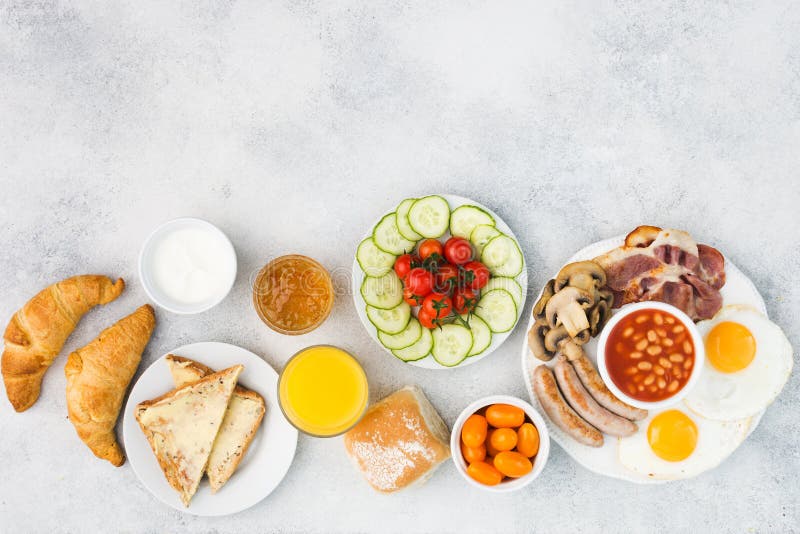 Café da manhã inglês completo, ovos, bacon, salsichas, pães e frutos imagem de stock Café da manhã inglês completo, ovos, bacon, salsichas, pães e frutos imagem de stock