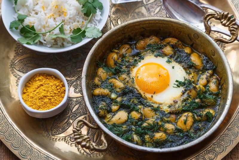 Café da manhã persa com ovos, feijão e aneto na bandeja de cobre
