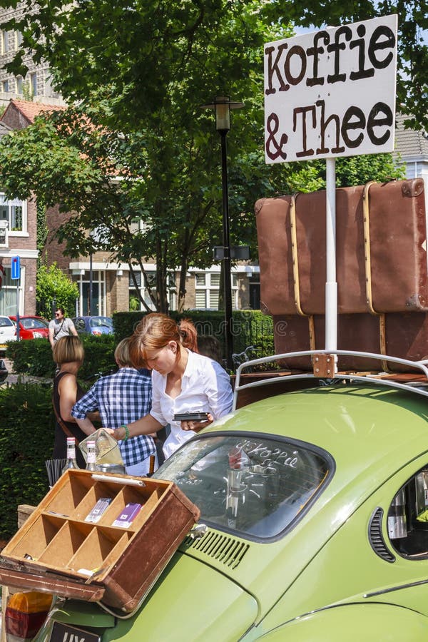 DORDRECHT, NETHERLANDS - AUGUSTUS 10, 2014: Pouring coffee, serving drinks out of a car at the summer Swan Market in Dordrecht. The lifestyle market was originally started in vacant shops in Rotterdam. DORDRECHT, NETHERLANDS - AUGUSTUS 10, 2014: Pouring coffee, serving drinks out of a car at the summer Swan Market in Dordrecht. The lifestyle market was originally started in vacant shops in Rotterdam