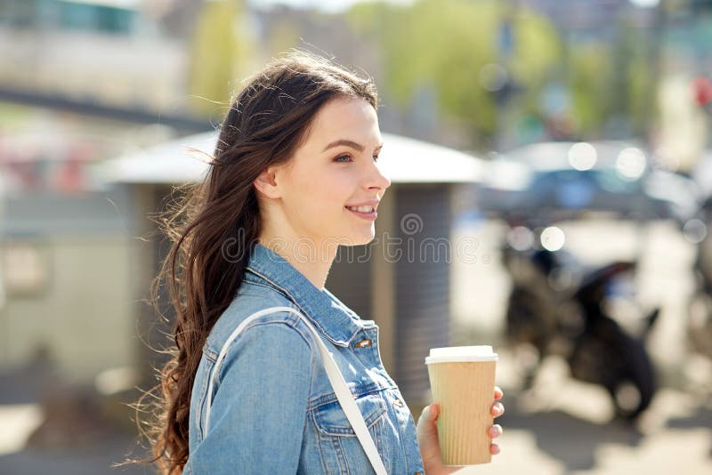 Café de consumición feliz de la mujer joven en la calle de la ciudad fotos de archivo libres de regalías Café de consumición feliz de la mujer joven en la calle de la ciudad fotos de archivo libres de regalías