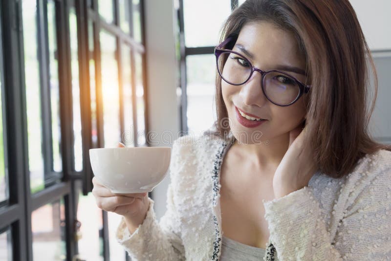Café de consumición de la mujer de negocios Chica joven feliz que sostiene la taza de té imagenes de archivo Café de consumición de la mujer de negocios Chica joven feliz que sostiene la taza de té imagenes de archivo
