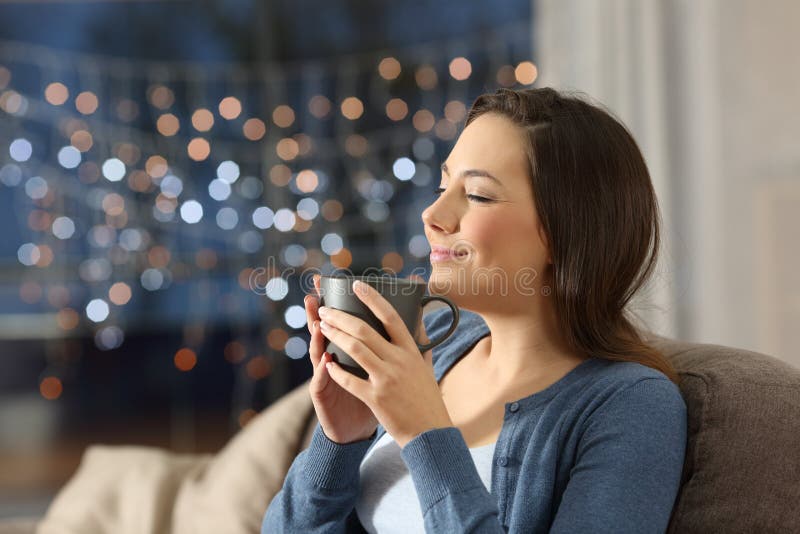 Café de consumición de relajación de la mujer en la noche en casa fotos de archivo libres de regalías