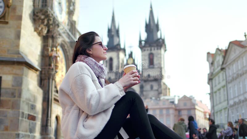 Café de relajación de la bebida de la mujer turística europea bonita en el cuadrado histórico con arquitectura que sorprende