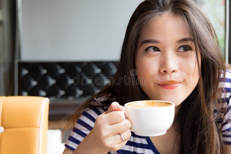 Café de sourire et potable de femme asiatique image stock Café de sourire et potable de femme asiatique image stock