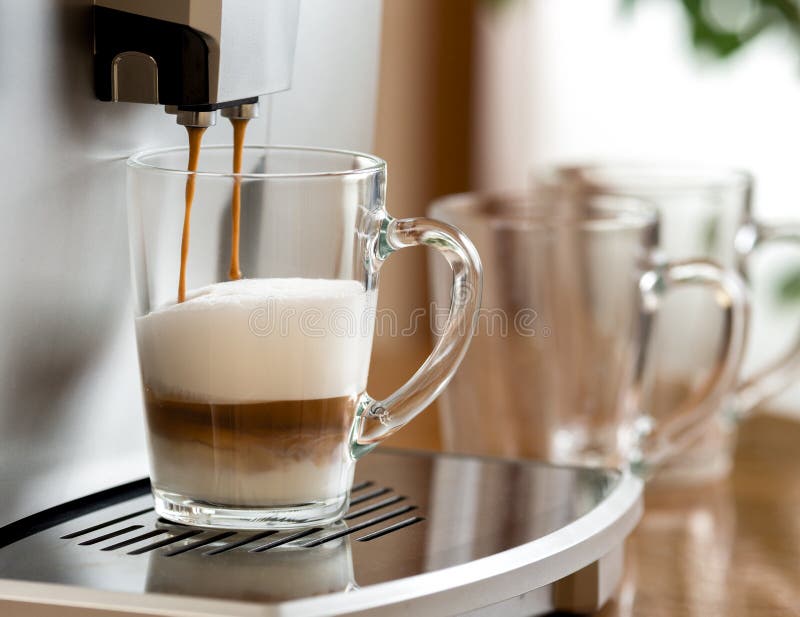 Café del capuchino que se prepara en la taza de cristal con la máquina imagenes de archivo Café del capuchino que se prepara en la taza de cristal con la máquina imagenes de archivo
