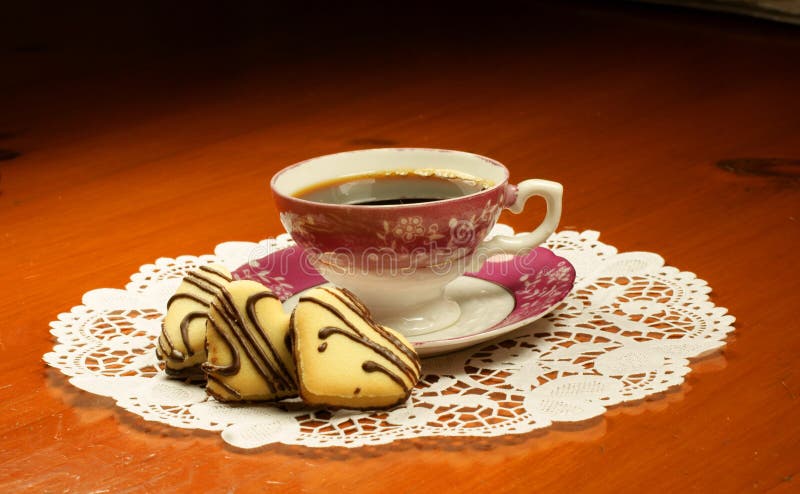 Pretty pink cup of coffee with heart shaped biscuits. Pretty pink cup of coffee with heart shaped biscuits