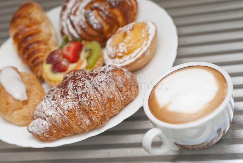 Cup of cappucino with a plate of pastries. Cup of cappucino with a plate of pastries