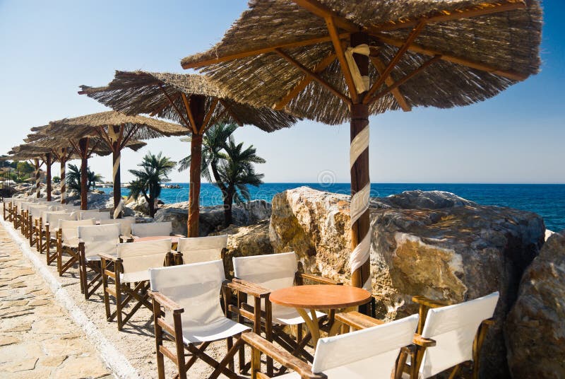 Welcoming beach cafe with straw parasols. Samos Island, Greece. Welcoming beach cafe with straw parasols. Samos Island, Greece