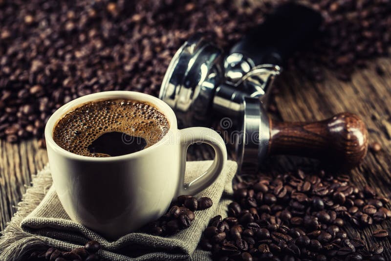 Café La tasse de coffe noir avec des grains de café trifouillent et portafilter photographie stock Café La tasse de coffe noir avec des grains de café trifouillent et portafilter photographie stock