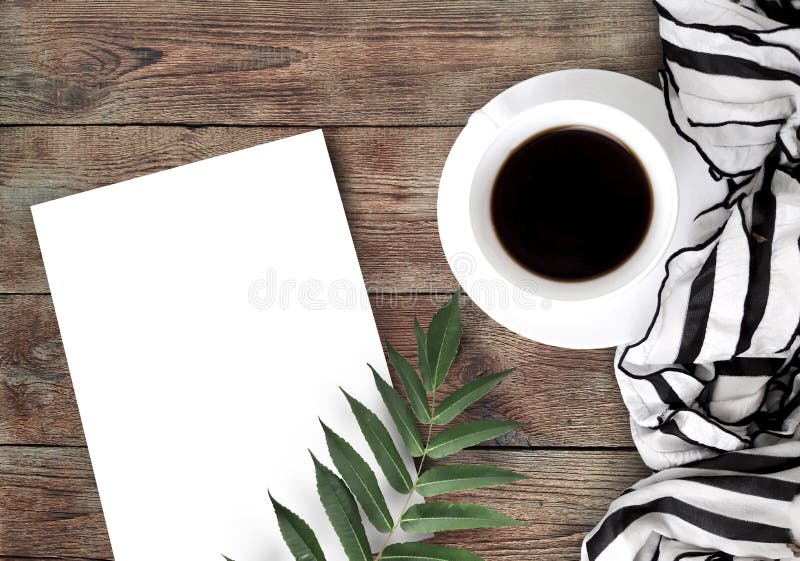 Café, lenço, placa de papel vazia e folha no fundo de madeira