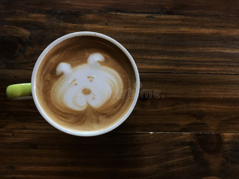Café lindo del arte del latte de la cara del perro en la taza blanca en la tabla de madera imagenes de archivo Café lindo del arte del latte de la cara del perro en la taza blanca en la tabla de madera imagenes de archivo