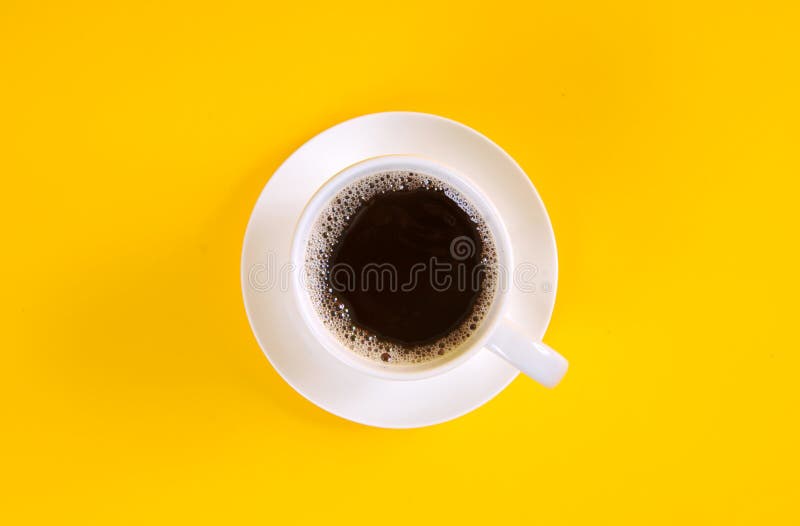 Café noir dans une tasse de café vue sur le dessus sur fond jaune photographie stock libre de droits Café noir dans une tasse de café vue sur le dessus sur fond jaune photographie stock libre de droits