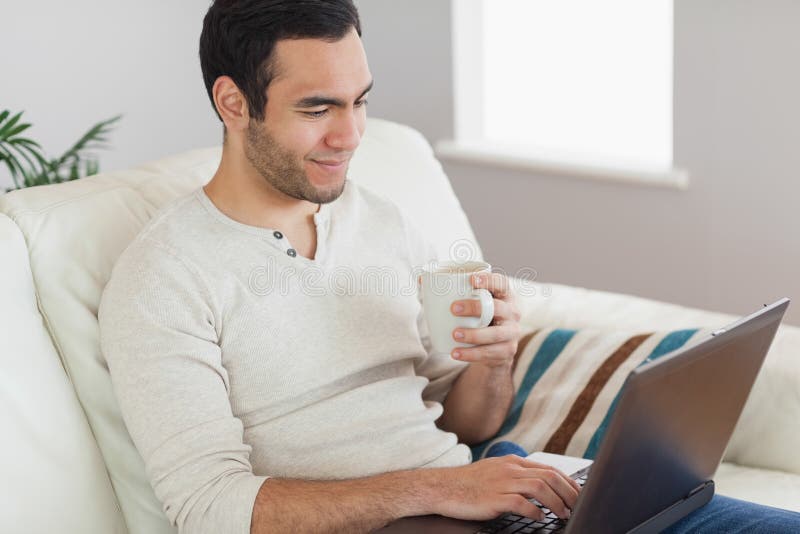Café potable d'homme attirant calme tout en travaillant sur son ordinateur portable images libres de droits Café potable d'homme attirant calme tout en travaillant sur son ordinateur portable images libres de droits