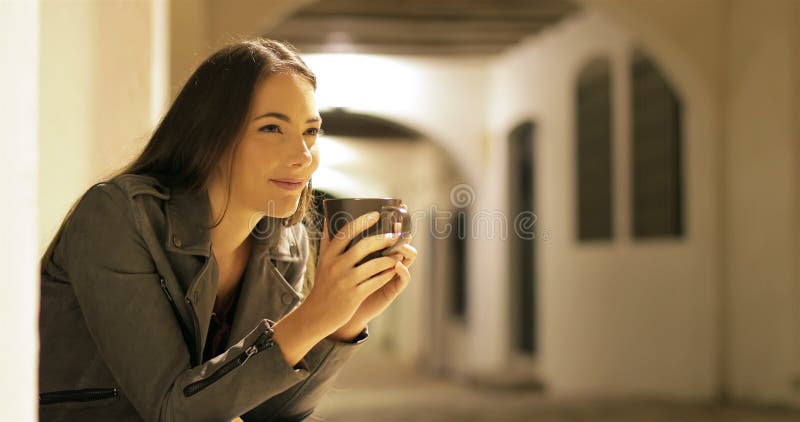 Café potable de femme heureuse dans la nuit