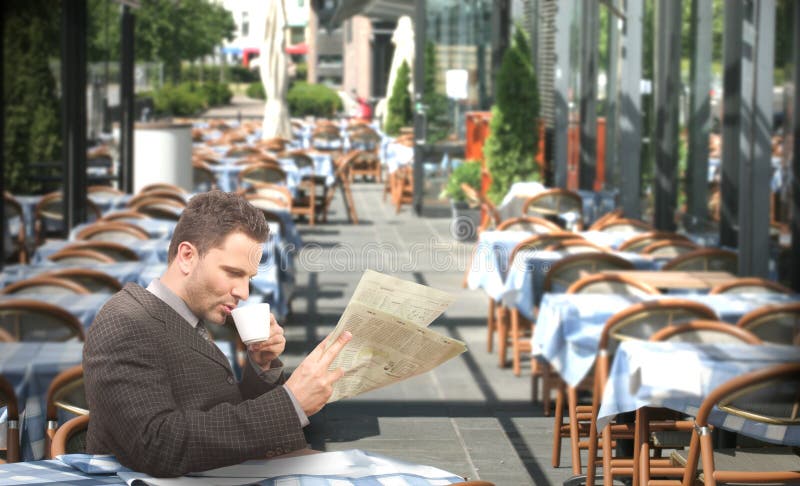 Café potable de repos et affichage d'homme d'affaires du journal dans le restaurant images stock Café potable de repos et affichage d'homme d'affaires du journal dans le restaurant images stock