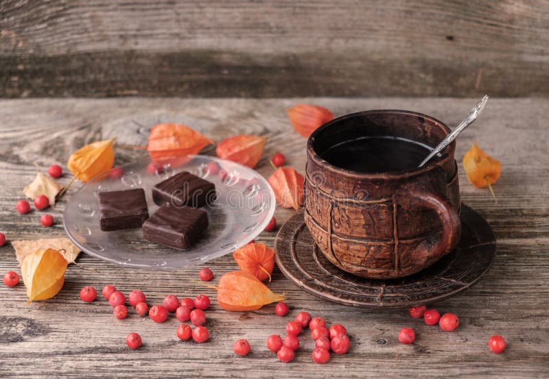 Café quente em uma caneca cerâmica e em chocolates imagens de stock royalty free Café quente em uma caneca cerâmica e em chocolates imagens de stock royalty free