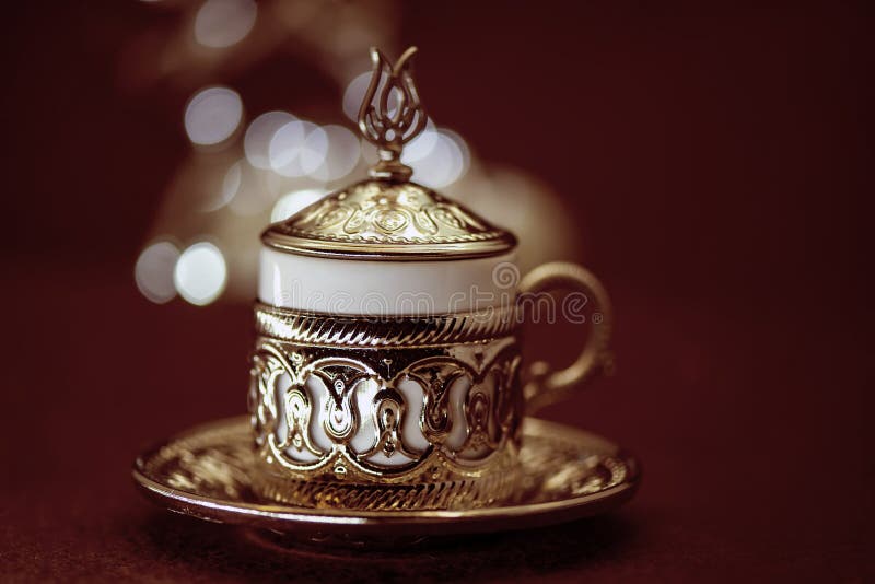 Café turc traditionnel dans la tasse traditionnelle en métal sur le fond brun avec le bokeh image stock Café turc traditionnel dans la tasse traditionnelle en métal sur le fond brun avec le bokeh image stock